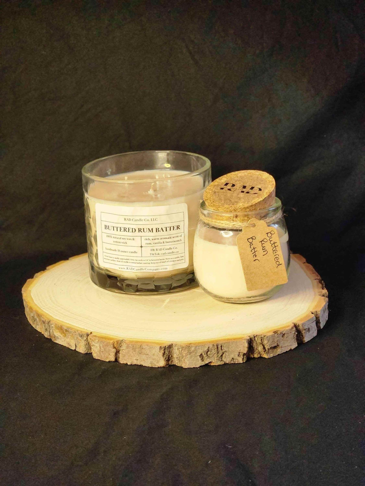 Buttered rum scented soy candle and buttered rum batter on a rustic wooden slice, showcasing cozy winter aromas.
